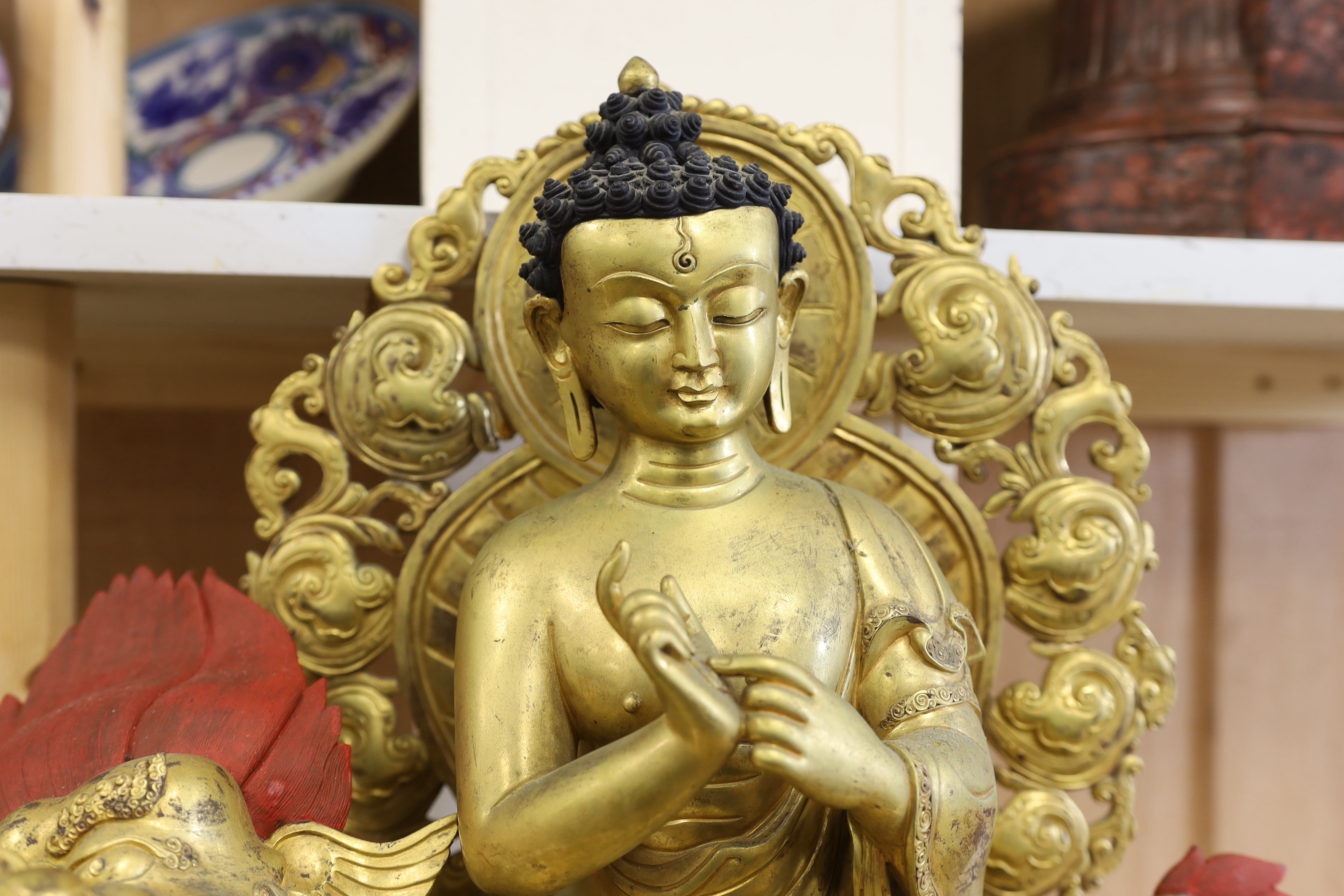 A massive Sino-Tibetan gilt bronze figure of Buddha seated on a lion, 51cm tall